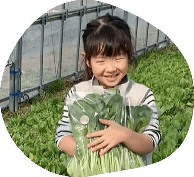 沢山の小松菜を抱える女の子